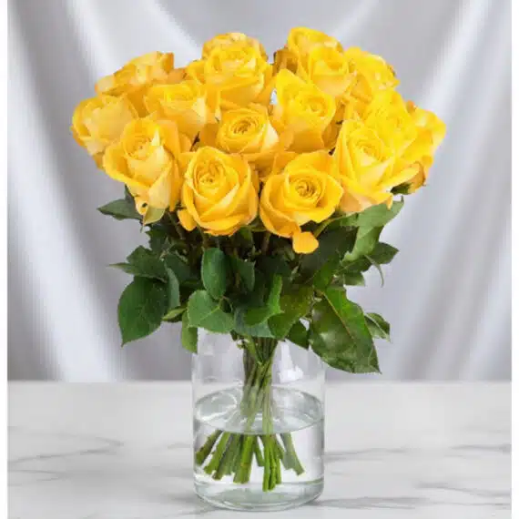 Arreglo Floral Elisabetta: 18 Rosas Amarillas para Amistad y Gratitud Arreglo floral Elisabetta con 18 rosas amarillas frescas en un jarrón de cristal, ideal para expresar amistad y gratitud.