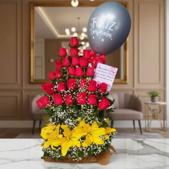 Arreglo floral exótico Gamma con rosas rojas, lirios amarillos y un globo de 'Feliz Cumpleaños' sobre una mesa de mármol en u