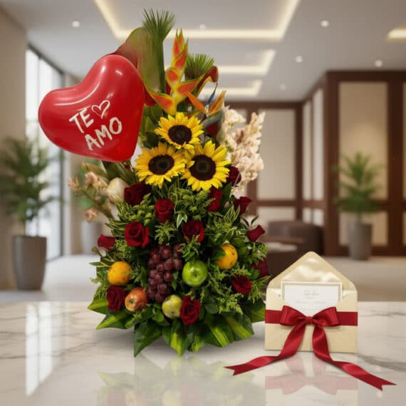 Arreglo floral con girasoles, rosas rojas, frutas tropicales, globo de corazón 'Te Amo' y tarjeta de regalo en un entorno ele